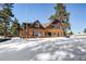 Log home exterior with snowy yard; mountain views in background at 21531 Main Ave, Golden, CO 80401