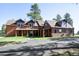 Exterior view of wood sided home with covered porch, manicured lawn and an asphalt driveway at 21531 Main Ave, Golden, CO 80401
