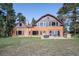 Exterior of home featuring wood siding, large windows, a patio and well-maintained lawn at 21531 Main Ave, Golden, CO 80401