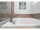 Luxurious bathtub with a shower panel and tiled walls at 24747 E Calhoun Pl # C, Aurora, CO 80016
