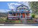 Charming home featuring a colorful exterior, inviting front porch, and landscaped garden at 209 10Th Ave, Idaho Springs, CO 80452