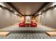 The basement features a cozy seating area with bright red chairs and custom lighting at 12565 Picadilly Rd, Commerce City, CO 80022