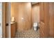 A modern powder bath featuring wood tile and a patterned tile floor at 12565 Picadilly Rd, Commerce City, CO 80022
