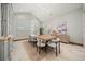 Bright dining room with large windows, shutters, modern light fixture and seating for eight at 12565 Picadilly Rd, Commerce City, CO 80022