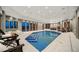 A luxurious indoor pool features tile steps, lounge chairs, and abundant natural light through sliding glass doors at 12565 Picadilly Rd, Commerce City, CO 80022