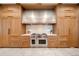 Modern eat-in kitchen featuring a Wolf range with hood and custom cabinets at 12565 Picadilly Rd, Commerce City, CO 80022