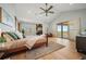 Large main bedroom featuring a fireplace, natural light, and access to an outdoor balcony with beautiful views at 12565 Picadilly Rd, Commerce City, CO 80022
