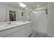 Bright bathroom featuring a double vanity, a glass-enclosed shower, and a walk-in closet at 9 N Waterloo St, Aurora, CO 80018