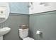 Stylish powder room with blue patterned wallpaper, gray wainscoting, and a pedestal sink at 9 N Waterloo St, Aurora, CO 80018
