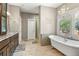 Elegant bathroom featuring a standalone tub, chandelier, mosaic tile, and dark wood vanity at 11433 Decatur Ct, Westminster, CO 80234