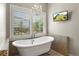 Bright bathroom with standalone tub, chandelier, and window views; an elegant private space at 11433 Decatur Ct, Westminster, CO 80234