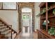 Elegant foyer featuring hardwood floors, a stone archway, and a grand staircase leading to the upper level at 11433 Decatur Ct, Westminster, CO 80234