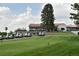 Scenic view of golf course with manicured green, golf carts lined up and a clubhouse in the background at 11433 Decatur Ct, Westminster, CO 80234