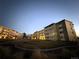 A view of the apartment building exterior at dusk, highlighting the building's design and landscaping at 9625 E Center Ave # 4C, Denver, CO 80247