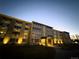 Building Exterior: Apartment building with a well-lit entrance at twilight at 9625 E Center Ave # 4C, Denver, CO 80247