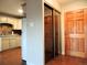 Kitchen with tan cabinetry, white appliances, and adjacent entry at 9625 E Center Ave # 4C, Denver, CO 80247