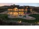 Stunning multi-story home with a pool and luxurious outdoor seating under a colorful sunset sky at 3148 Keep Dr, Sedalia, CO 80135