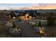 Charming two-story home with stone and wood details, manicured landscaping, and a paved circular driveway at 3148 Keep Dr, Sedalia, CO 80135