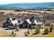 Beautiful, modern two-story home with stone and wood accents, a circular driveway, and picturesque mountain views at 3148 Keep Dr, Sedalia, CO 80135