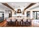 Gourmet kitchen featuring an island, barstool seating, wood beams, and pendant lighting at 3148 Keep Dr, Sedalia, CO 80135