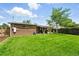 Grassy backyard featuring a brick home extension and a covered patio with seating and landscaped details at 2461 Niagara St, Denver, CO 80207