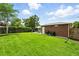 Lush green backyard featuring a brick structure, manicured lawn, patio seating, and well-maintained wooden fence at 2461 Niagara St, Denver, CO 80207