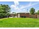 Beautifully manicured backyard with a brick structure, patio set, vibrant green grass, and a wooden fence at 2461 Niagara St, Denver, CO 80207
