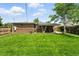Lush green backyard with a brick house, a covered patio, and a wooden fence; perfect for outdoor enjoyment at 2461 Niagara St, Denver, CO 80207