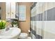 Compact bathroom with white fixtures, including a sink and toilet, plus a tiled shower with curtain at 2461 Niagara St, Denver, CO 80207
