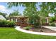 Charming brick home featuring a well-manicured lawn, garden beds and a welcoming walkway at 2461 Niagara St, Denver, CO 80207