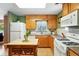 Bright kitchen with an island, wooden cabinets, and modern white appliances at 2461 Niagara St, Denver, CO 80207