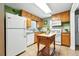 Well-lit kitchen boasts wood cabinets, white appliances, and a portable butcher block island at 2461 Niagara St, Denver, CO 80207