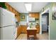 Functional kitchen with wooden cabinets, white appliances, an island and green walls at 2461 Niagara St, Denver, CO 80207