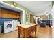 Spacious kitchen with wood cabinets, an island and an adjacent laundry area and living room at 2461 Niagara St, Denver, CO 80207