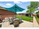 Outdoor patio with dining set, blue umbrella, brick accents, and lawn views; ideal for relaxing and entertaining at 2461 Niagara St, Denver, CO 80207