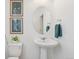 Bathroom featuring pedestal sink, oval mirror, and neutral decor at 8926 Swan River St, Littleton, CO 80125