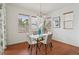 Dining room with wood floors, modern chandelier, and lots of natural light from the windows at 8926 Swan River St, Littleton, CO 80125
