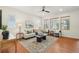 Bright living room featuring hardwood floors, a ceiling fan, a contemporary rug, and large windows at 8926 Swan River St, Littleton, CO 80125