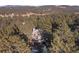 A high aerial view of the house nestled in a dense forest at 2492 Baldy Ln, Evergreen, CO 80439