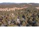 A high aerial view of the house nestled in a dense forest in a mountain community at 2492 Baldy Ln, Evergreen, CO 80439