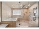 Luxurious bathroom featuring a soaking tub, glass shower, and neutral tile throughout at 2492 Baldy Ln, Evergreen, CO 80439