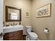 Well-lit powder room featuring a modern sink and vanity, toilet, and framed artwork at 2492 Baldy Ln, Evergreen, CO 80439