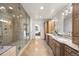 Spacious bathroom featuring double sinks, a walk-in shower, and neutral tiling at 2492 Baldy Ln, Evergreen, CO 80439