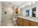 Bathroom featuring granite countertops, double sinks, a shower, and wood cabinets at 2492 Baldy Ln, Evergreen, CO 80439