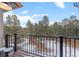 A beautiful view from the deck showing the forest and wintery landscape through black metal railings at 2492 Baldy Ln, Evergreen, CO 80439