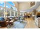 Bright living room featuring large windows, a cozy seating area, and seamless flow into the kitchen at 2492 Baldy Ln, Evergreen, CO 80439