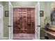 Custom wine cellar with wood racking, tiled floor, and glass door at 2492 Baldy Ln, Evergreen, CO 80439