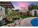 Landscaped backyard featuring a water feature, lush greenery, and a partial view of the pool at 4329 S Clarkson St, Englewood, CO 80113
