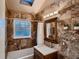 Bathroom with earth-toned tile, a skylight, and a shower-tub combination at 4329 S Clarkson St, Englewood, CO 80113
