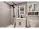 Modern bathroom with gray tiled shower, modern white vanity, and matching medicine cabinet for storage at 4329 S Clarkson St, Englewood, CO 80113